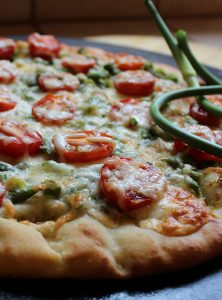 pizza aux fleurs d'ail fraîches et aux tomates cerises